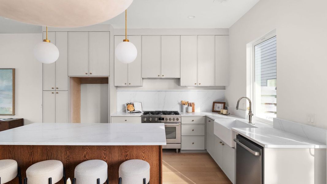 Kitchen featuring a kitchen breakfast bar, white cabinetry, appliances with stainless steel finishes, and a center island