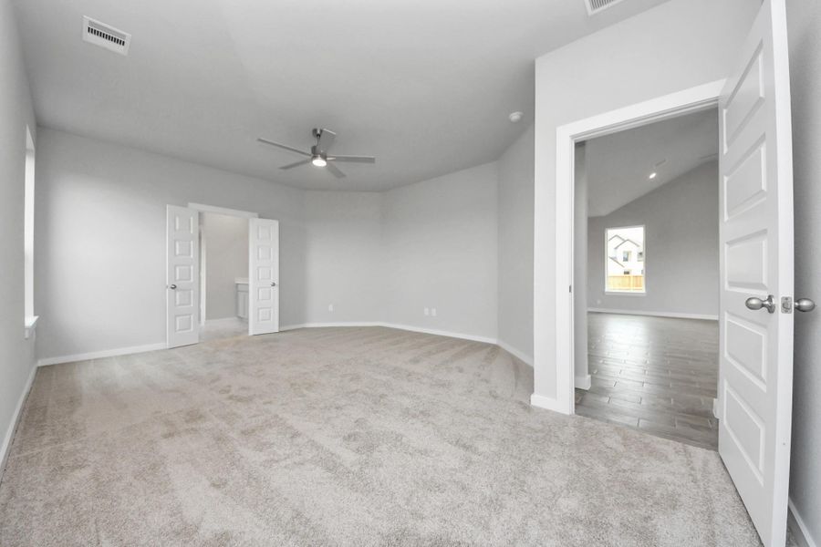Come and unwind after a long day in this magnificent primary suite! This spacious room features plush carpet, warm paint, high ceilings and large windows with privacy blinds. Sample photo of completed home with similar floor plan. Actual colors and selections may vary.