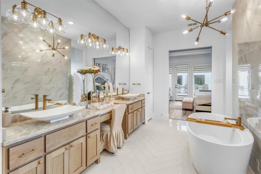 A luxury spa! This is what dreams are made of! Stunning custom tile flooring, gold accents, quartzite countertops and tile, large soaking tub, large vessel sinks, vanity, and modern pendant lighting.