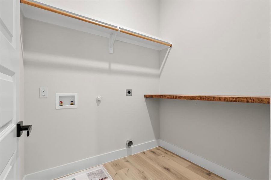 Laundry area featuring hookup for a gas dryer, hookup for a washing machine, light hardwood / wood-style floors, and hookup for an electric dryer