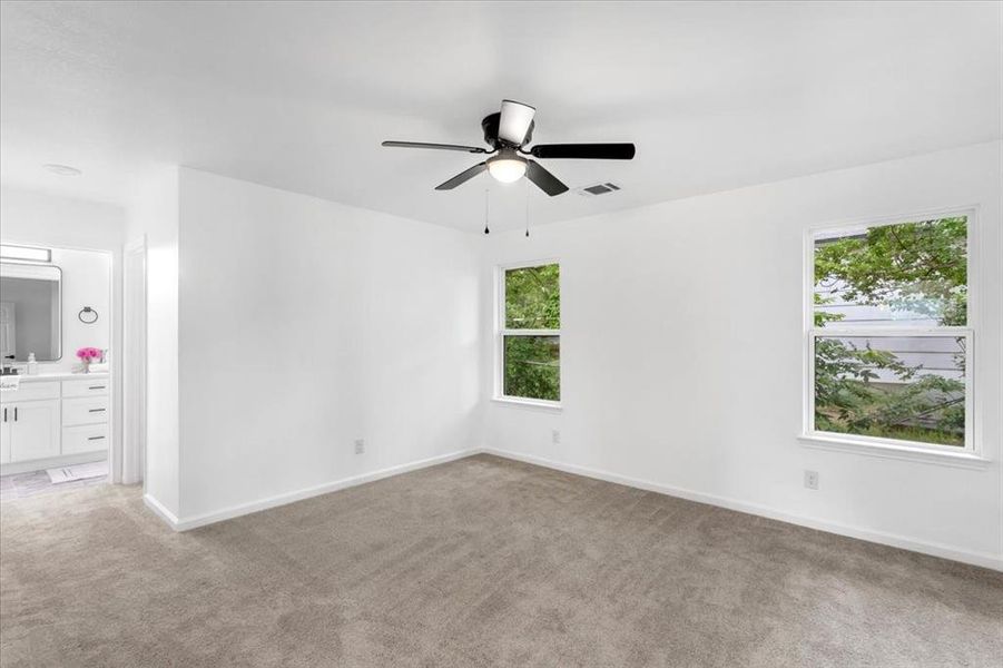 Master bedroom with ceiling fan and light carpet