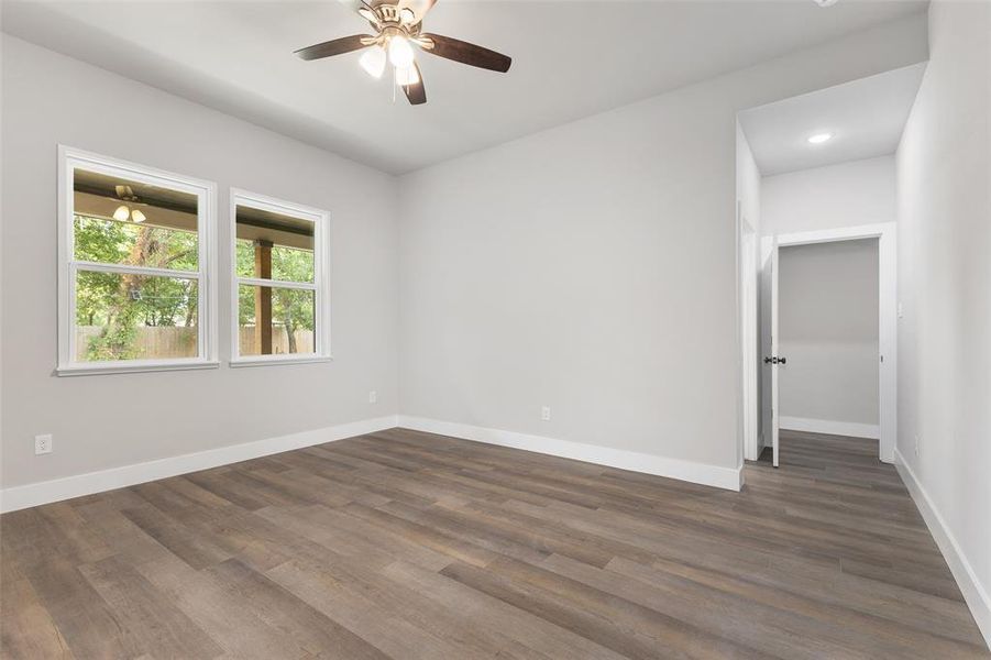 Spare room with dark wood-type flooring and ceiling fan