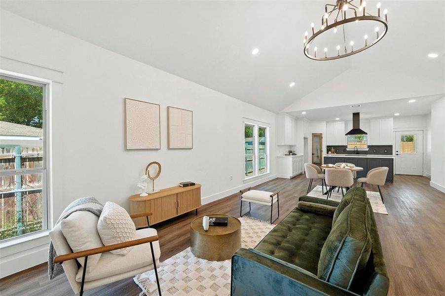 Living area featuring wood finished floors, recessed lighting, a chandelier, and high vaulted ceiling