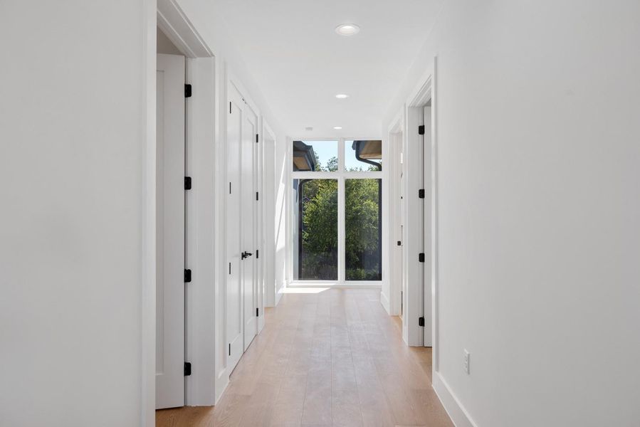Corridor with recessed lighting, expansive windows, and light wood-style flooring Corridor with recessed lighting, expansive windows, and light wood-style flooring