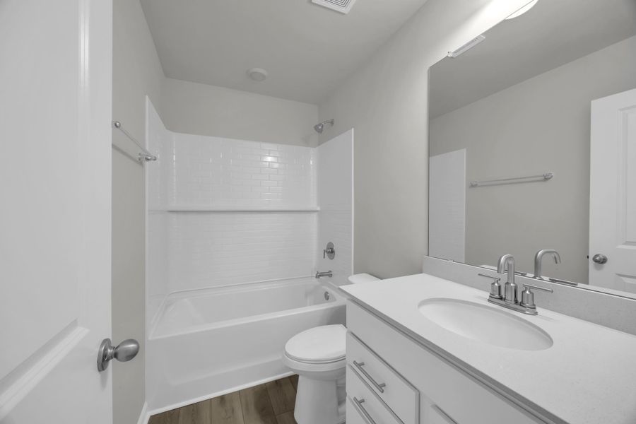 Full bath featuring shower / bath combination, vanity, and dark wood-style flooring