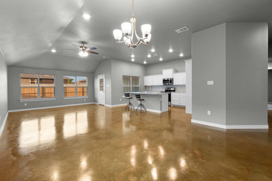 An open-concept living area with gleaming concrete floors and a modern kitchen.