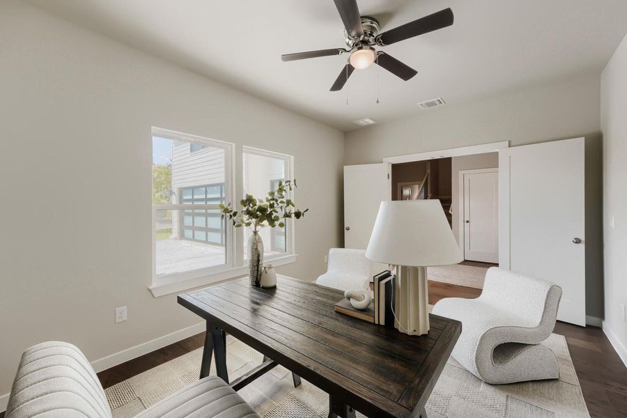 A dedicated home office provides a private workspace, featuring a ceiling fan and rich hardwood flooring. A dedicated home office provides a private workspace, featuring a ceiling fan and rich hardwood flooring.