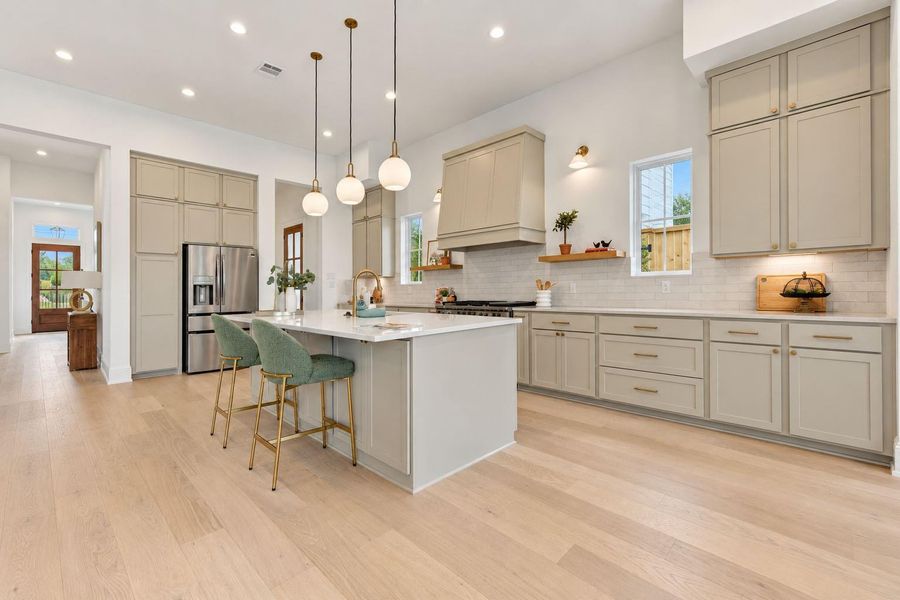 Stunning open-concept kitchen featuring an oversized island with seating, quartz countertops, sleek cabinetry, designer pendant lighting, and modern finishes. The spacious layout flows seamlessly into the living and dining areas, creating an inviting setting for everyday living and entertaining. Stunning open-concept kitchen featuring an oversized island with seating, quartz countertops, sleek cabinetry, designer pendant lighting, and modern finishes. The spacious layout flows seamlessly into the living and dining areas, creating an inviting setting for everyday living and entertaining.