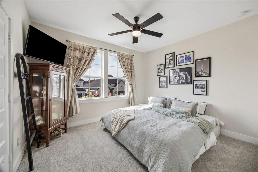 A spacious upstairs secondary bedroom with soft carpeting, great natural light, and a generous closet for comfortable everyday living.