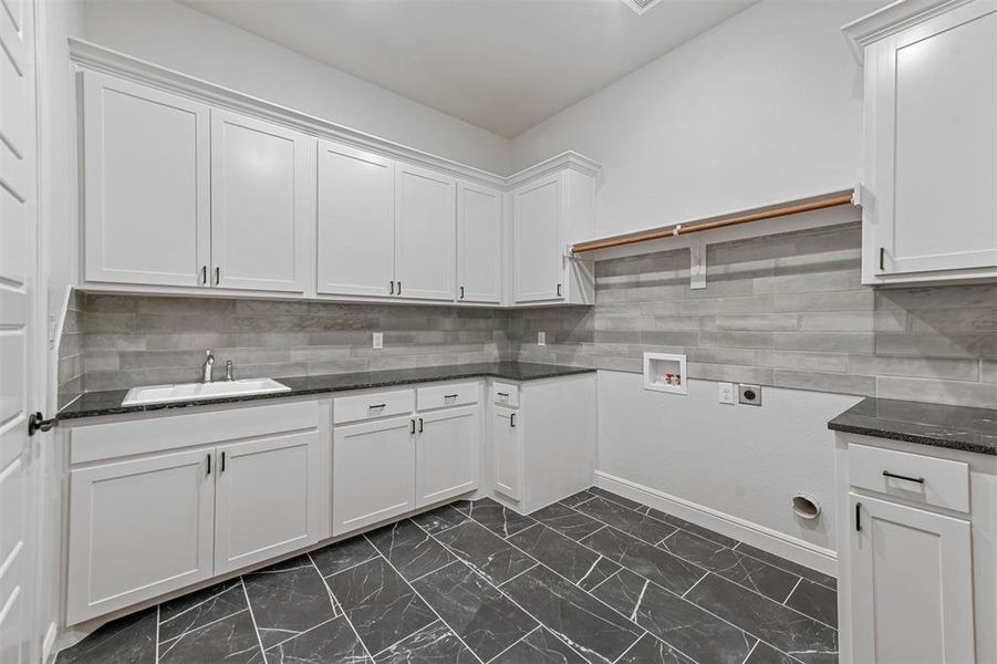 Washroom featuring hookup for an electric dryer, washer hookup, cabinets, and sink