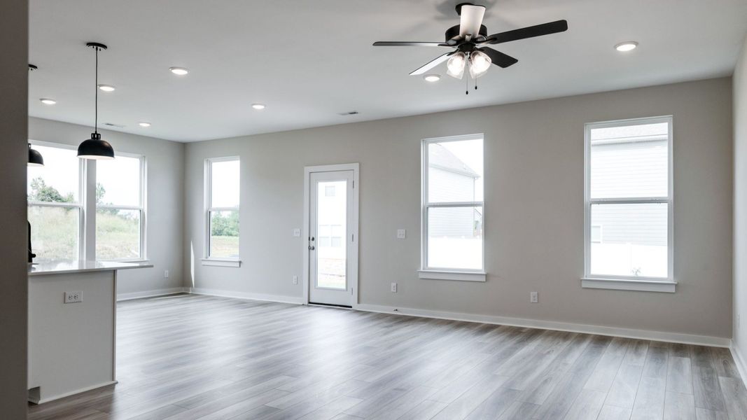 Spacious living area next to kitchen and dining area paired with natural lighting