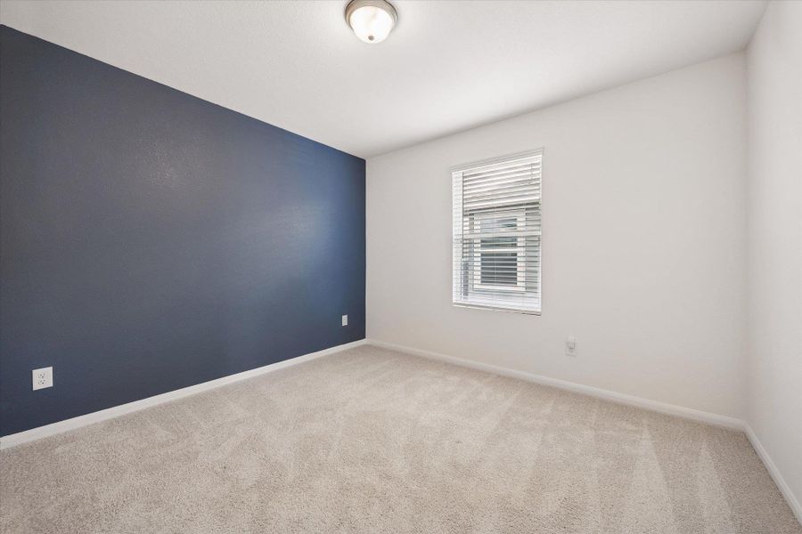 Spare room featuring light colored carpet and an accent wall