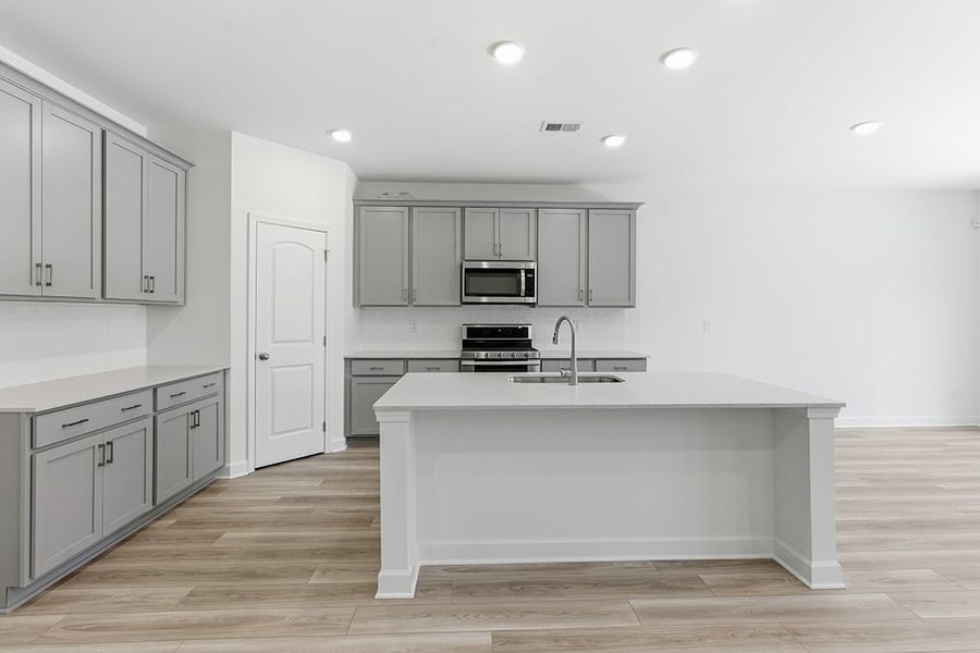 A kitchen with white cabinets.