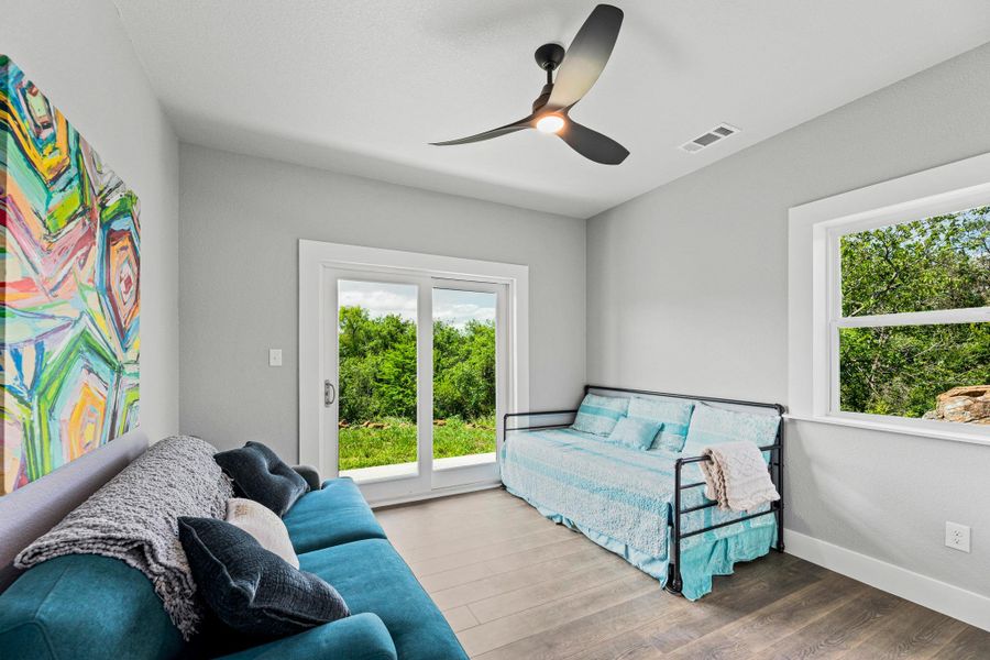 Room featuring wood-finish flooring, a contemporary ceiling fan, and light gray walls