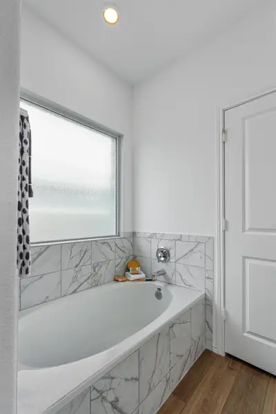Full bath featuring wood finished floors, a garden tub, and recessed lighting