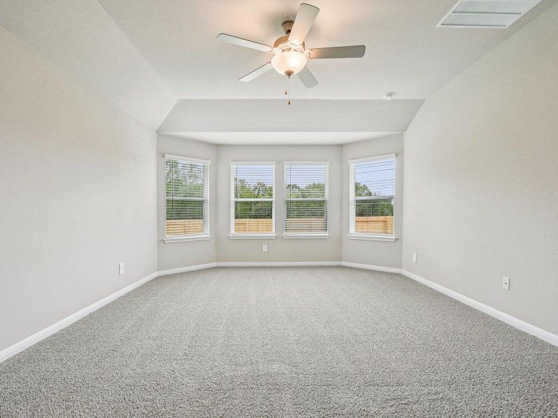 Empty room featuring carpet floors, lofted ceiling, and a ceiling fan Empty room featuring carpet floors, lofted ceiling, and a ceiling fan