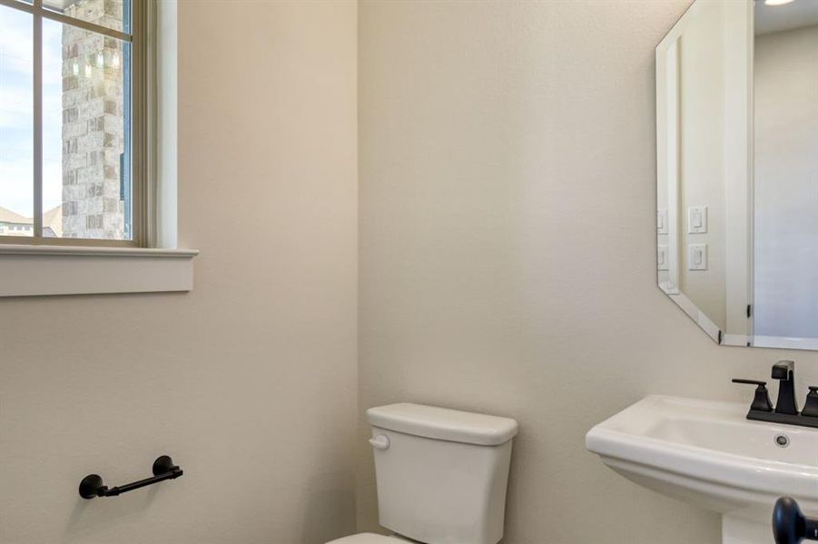 Half bathroom with toilet and a sink Half bathroom with toilet and a sink