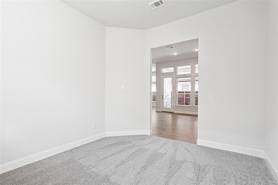 Carpeted empty room featuring baseboards