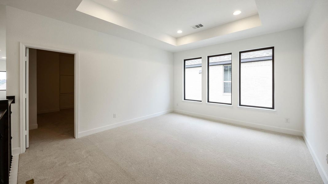Unfurnished room featuring a raised ceiling, light carpet, and recessed lighting
