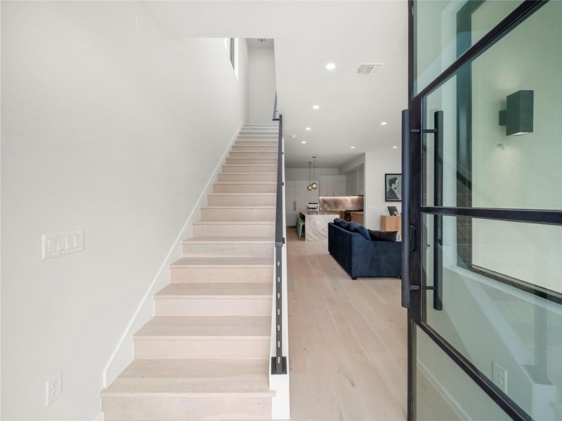 Stairs featuring wood finished floors and recessed lighting