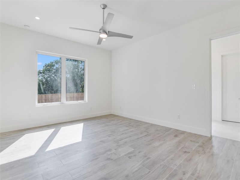 Bedroom featuring light wood-style floors, ceiling fan, and baseboards