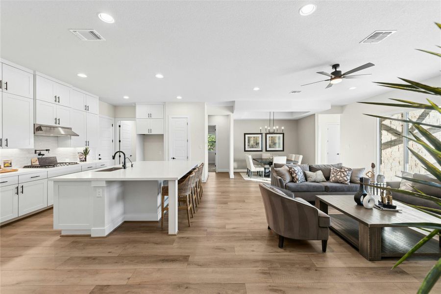 Living room featuring light wood-style flooring, recessed lighting, and a ceiling fan Living room featuring light wood-style flooring, recessed lighting, and a ceiling fan