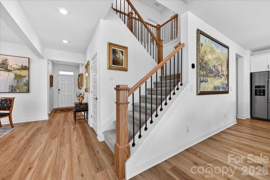 Gorgeous staircase leading upstairs with wrought-iron spindles.