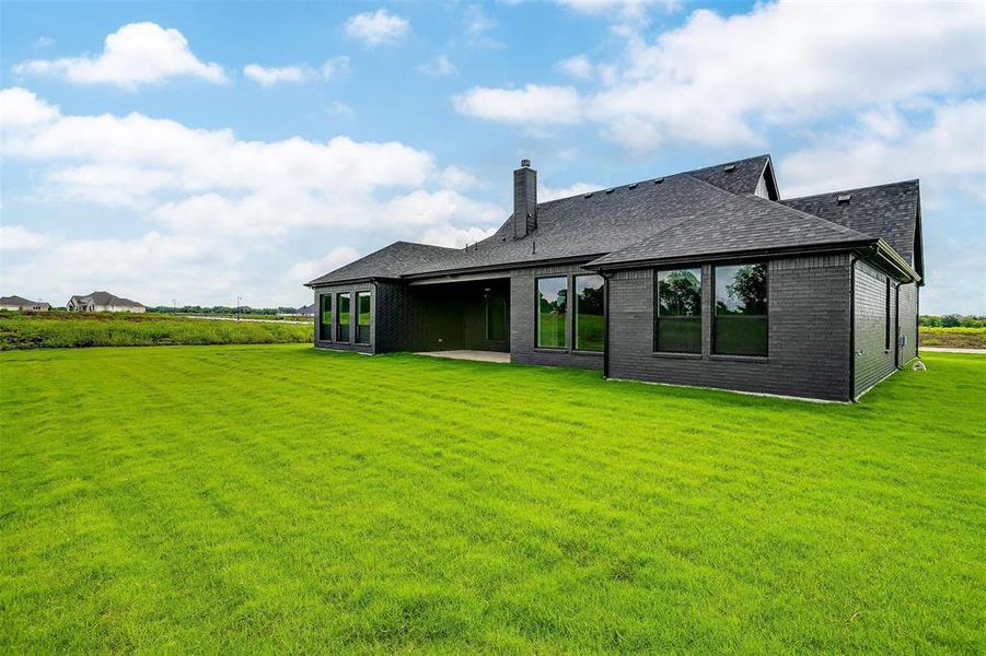 Back of house featuring a patio area and a lawn