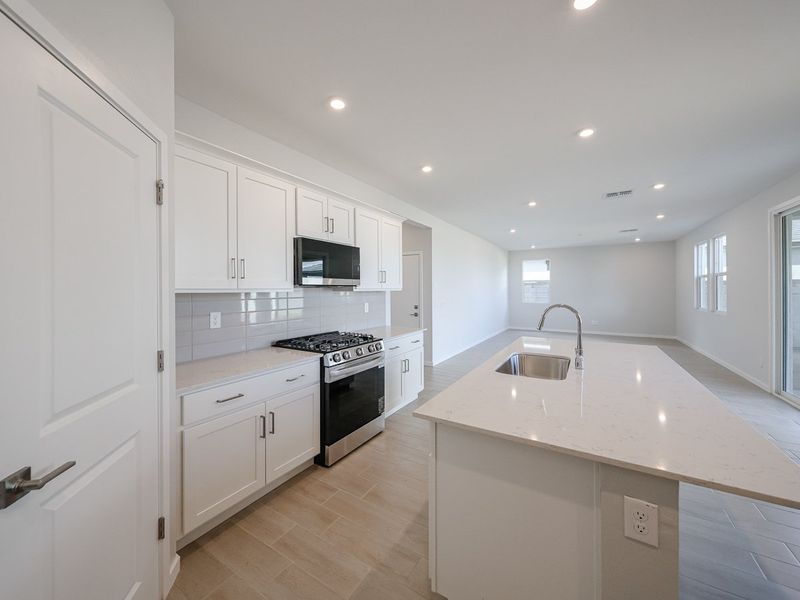 A kitchen with white cabinets.