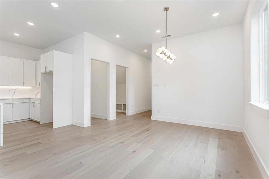 Unfurnished dining area with light wood-style flooring, recessed lighting, and baseboards