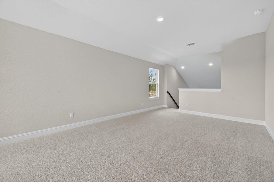 Additional living space featuring light carpet, vaulted ceiling, and recessed lighting