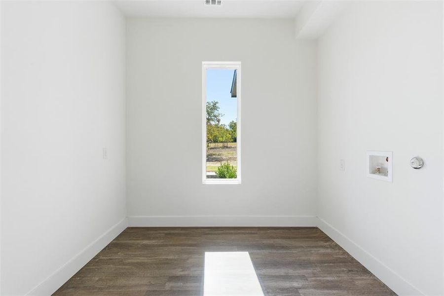 Washroom with dark wood-type flooring and washer hookup Washroom with dark wood-type flooring and washer hookup