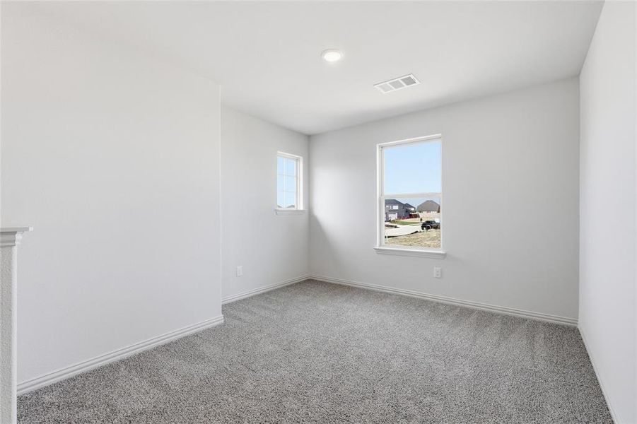 Bright interior space featuring light gray carpeting, crisp white walls, and two windows