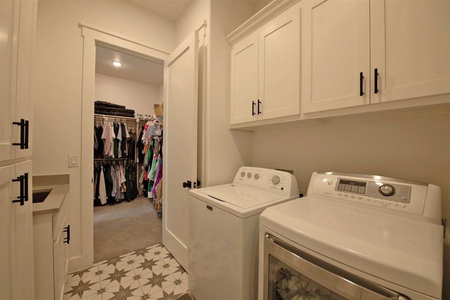 Laundry area with cabinet space, light colored carpet, and washer and clothes dryer