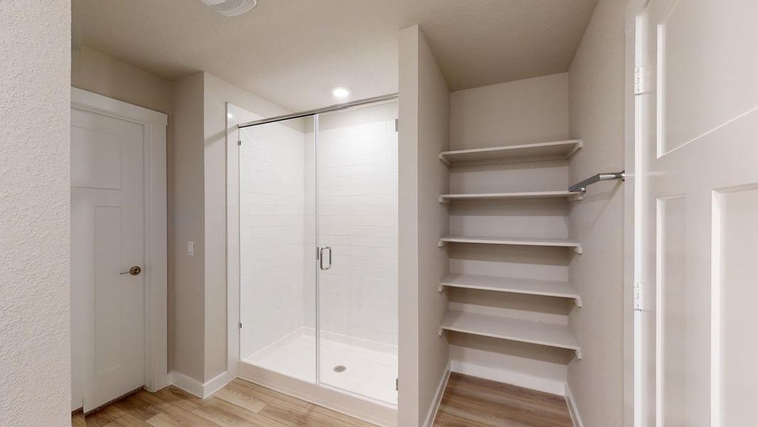 Bathroom with a shower stall, light wood-style floors, a closet, and recessed lighting