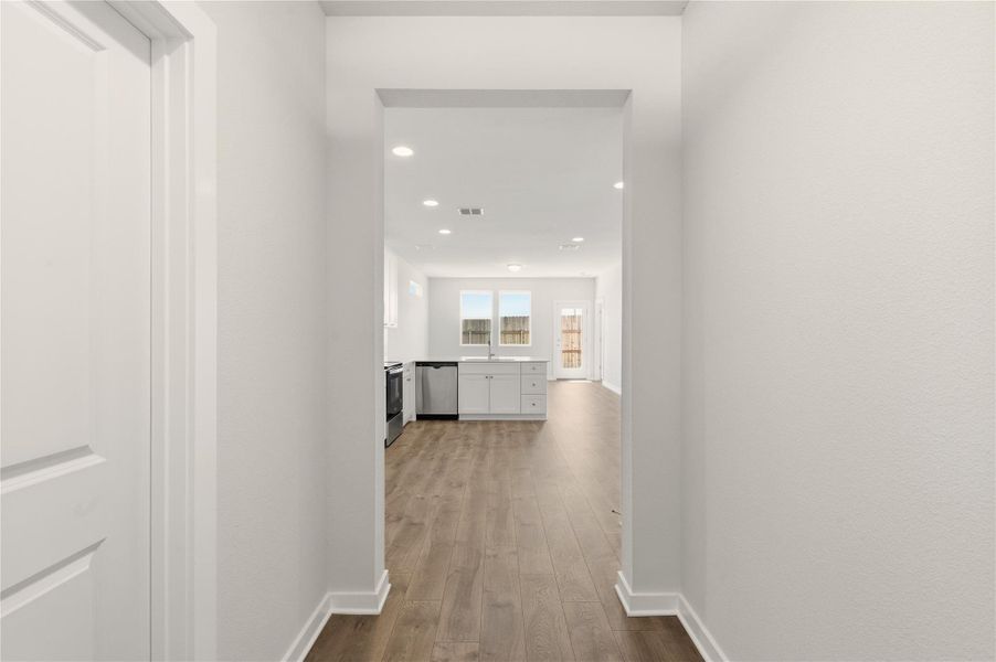 Corridor featuring wood finished floors and recessed lighting