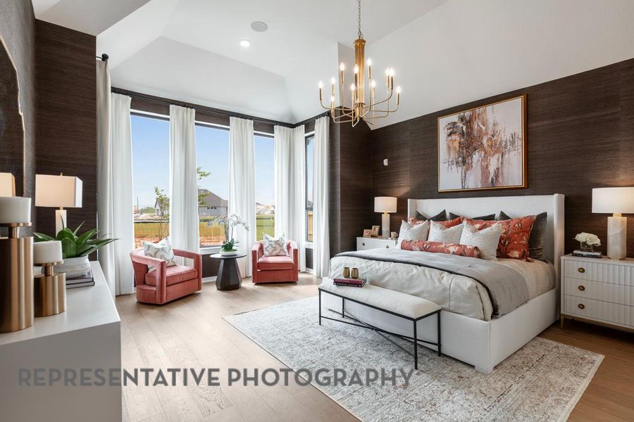 Bedroom with high vaulted ceiling, a chandelier, and wood finished floors