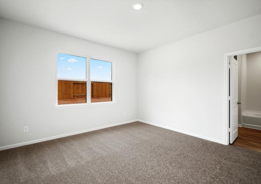 The master bedroom has a large window and carpet.