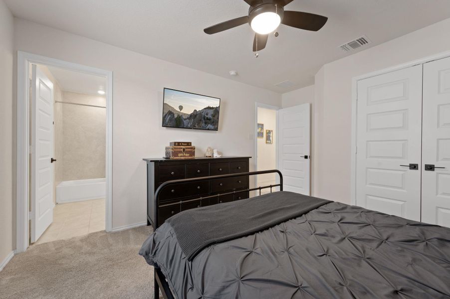 Bedroom featuring light carpet, ceiling fan, and a closet
