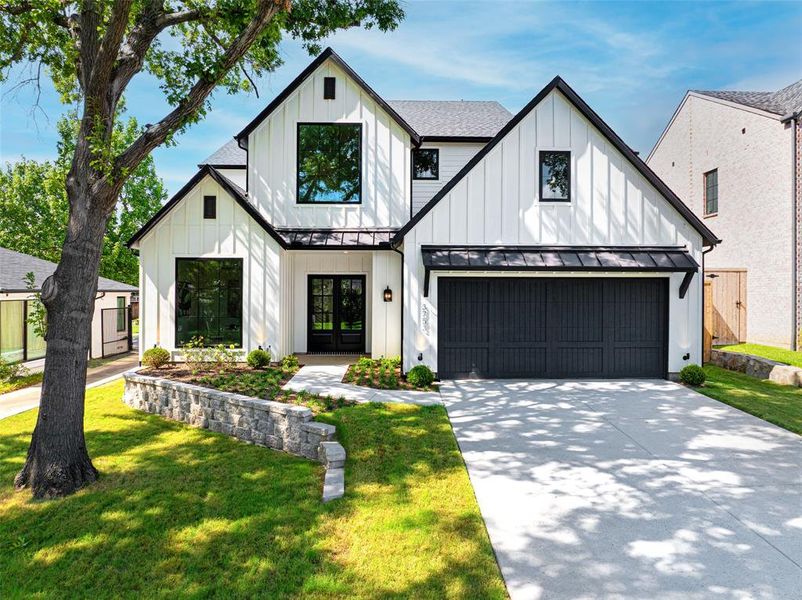 Modern farmhouse style home with board and batten siding, a standing seam roof, a metal roof, and a front yard Modern farmhouse style home with board and batten siding, a standing seam roof, a metal roof, and a front yard