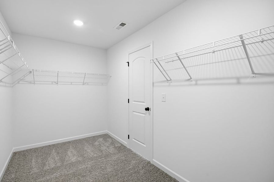 A white hallway with a metal railing.