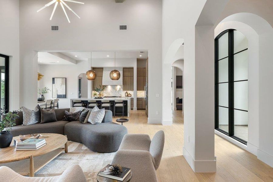 Open-concept living space with high ceilings and light wood-finish flooring