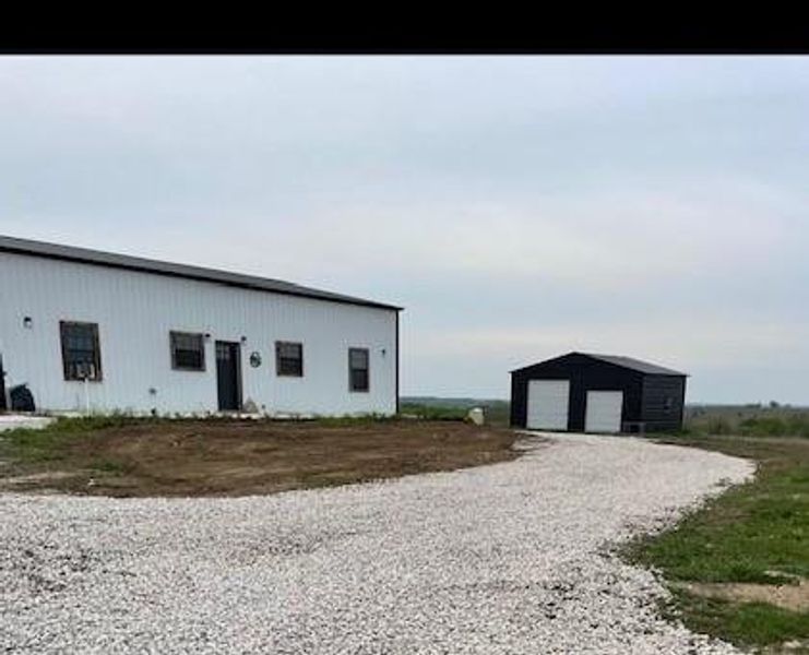 View of front of house featuring a garage and an outdoor structure