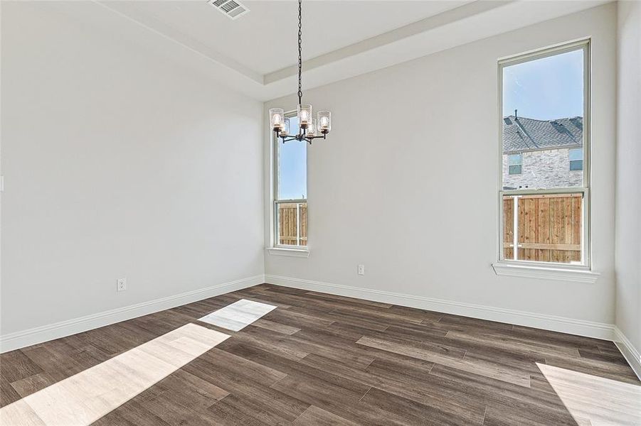 Unfurnished room with a wealth of natural light and dark wood-type flooring