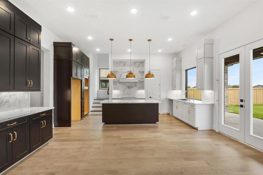 SAMPLE This kitchen is an entertainers dream come true! Sizeable island, perfect for gathering. Stacked cabinets and porcelain counters add an elegant touch!