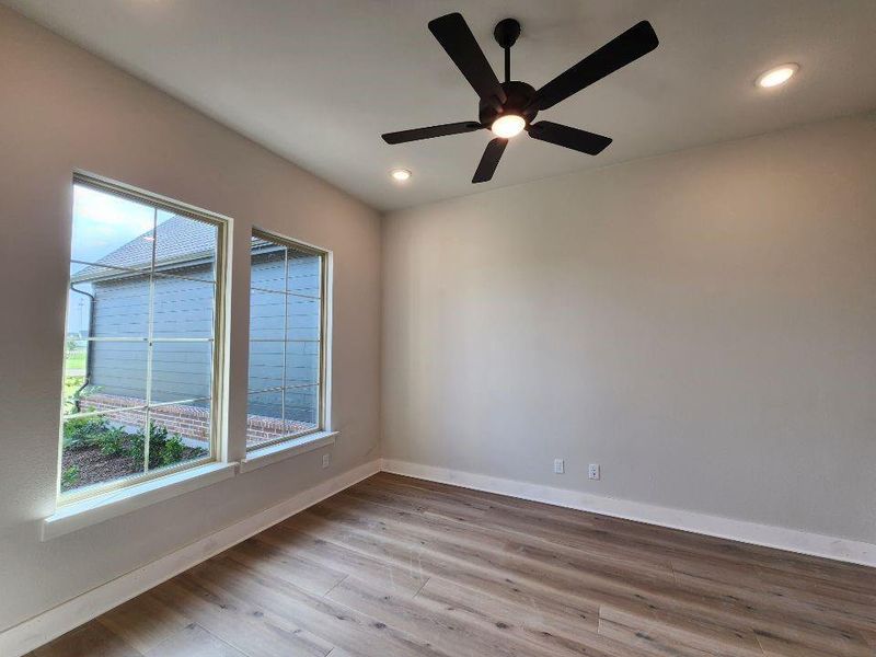 Room featuring dual windows with grid patterns, recessed lighting, and a black ceiling fan