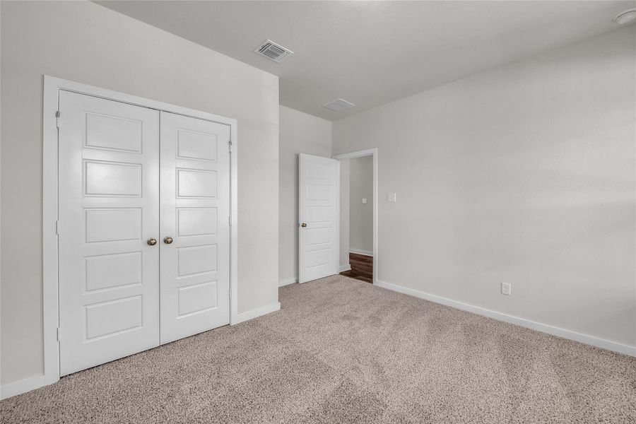 Unfurnished bedroom with carpet floors and a closet Unfurnished bedroom with carpet floors and a closet