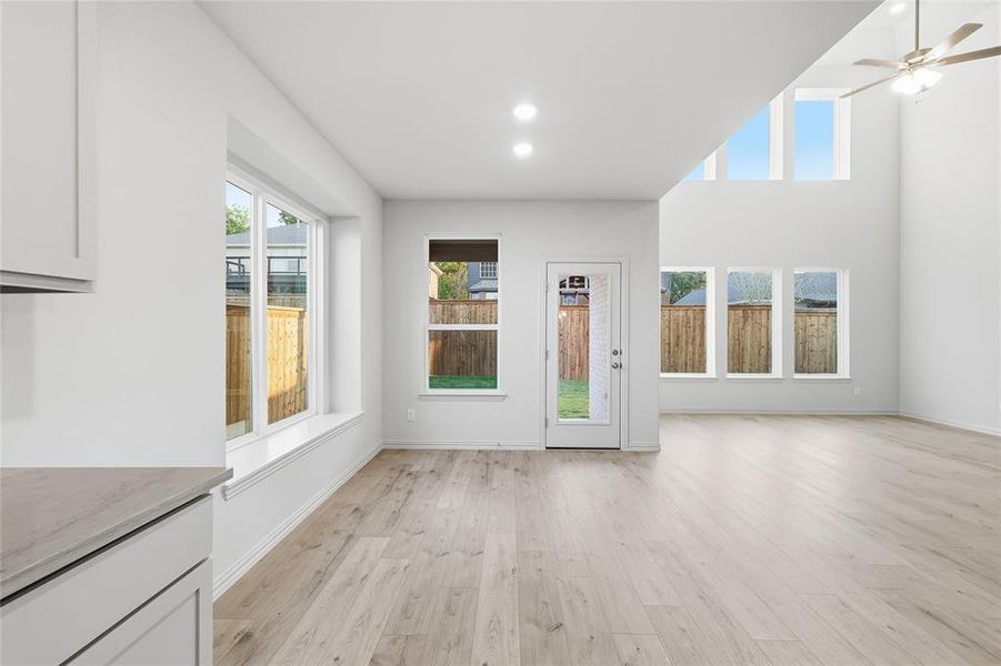 Unfurnished living room with light wood-type flooring, a ceiling fan, and recessed lighting