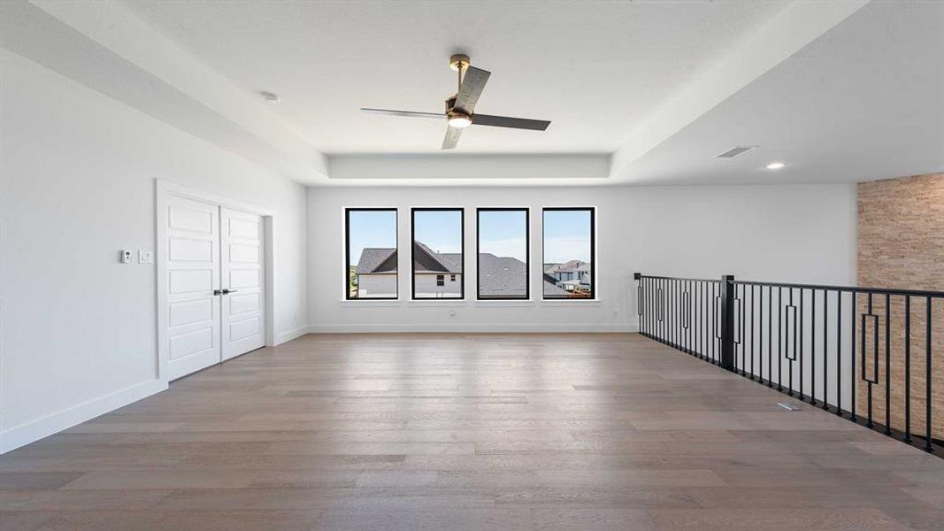 Unfurnished room featuring a ceiling fan, a tray ceiling, wood finished floors, and recessed lighting