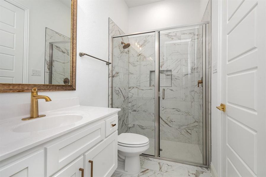 Bathroom with light marble finish floors, vanity, and a marble finish shower